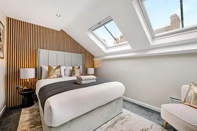 a bedroom with a large bed and two windows at Host & Stay - Halifax House Living in Liverpool