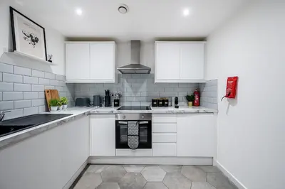 a white kitchen with white cabinets and appliances at Host & Stay - Halifax House Living in Liverpool