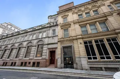 a large stone building on a city street at Host & Stay - Halifax House Living in Liverpool