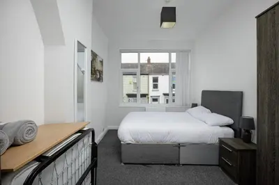 a white bedroom with a bed and a window at Lovely Home in Blackpool For You in Blackpool
