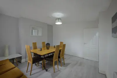 a dining room with a wooden table and chairs at Lovely Home in Blackpool For You in Blackpool