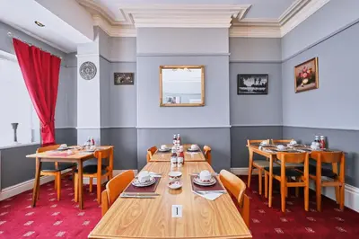 a dining room with wooden tables and chairs at The Wilton International in Blackpool