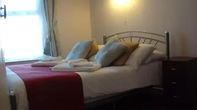 a bedroom with a bed with pillows and a window at The Wilton International in Blackpool