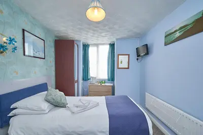 a bedroom with a bed with blue walls at The Wilton International in Blackpool