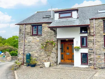 a small stone house with a wooden door at The Hayloft, Broughton Beck, near Ulverston budget friendly accommodation close to a beach and Windermere in Spark Bridge