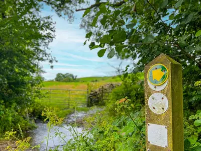 a sign in the middle of a path at The Hayloft, Broughton Beck, near Ulverston budget friendly accommodation close to a beach and Windermere in Spark Bridge