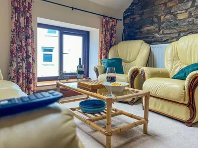 a living room with yellow chairs and a table at The Hayloft, Broughton Beck, near Ulverston budget friendly accommodation close to a beach and Windermere in Spark Bridge