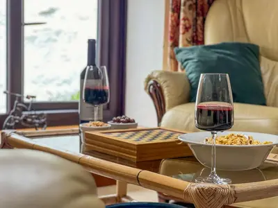 a table with a bowl of food and a glass of wine at The Hayloft, Broughton Beck, near Ulverston budget friendly accommodation close to a beach and Windermere in Spark Bridge