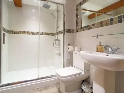 a bathroom with a shower and a toilet and a sink at The Stable, Broughton Beck, a ground floor cottage close to a beach and Windermere in Spark Bridge