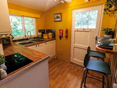 a kitchen with yellow walls and wooden floors and a counter at Lytham Hall Gate House in Lytham St Annes