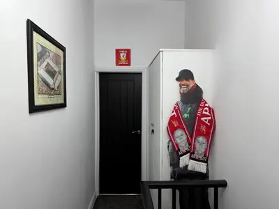 a picture of a man standing in front of a door at Anfield Abode - ENTIRE LFC THEMED HOUSE - Sleeps 6 in Liverpool