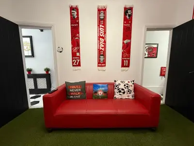 a red couch sitting in a living room with pillows at Anfield Abode - ENTIRE LFC THEMED HOUSE - Sleeps 6 in Liverpool