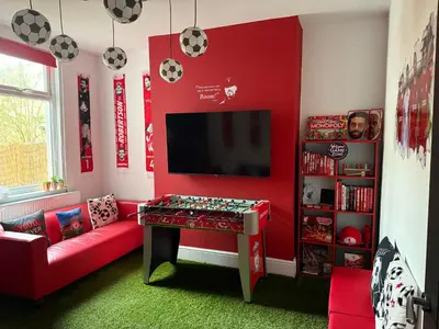a red living room with a red couch and a table at Anfield Abode - ENTIRE LFC THEMED HOUSE - Sleeps 6 in Liverpool