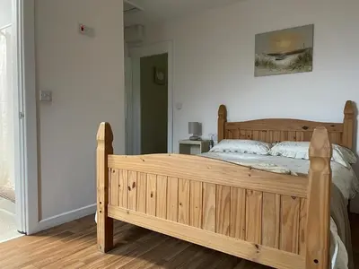 a wooden bed in a bedroom with a wooden floor at Another Place in Formby