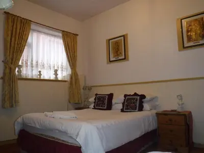 a bedroom with two beds and a window at Camelot Hotel - Couples Only in Blackpool