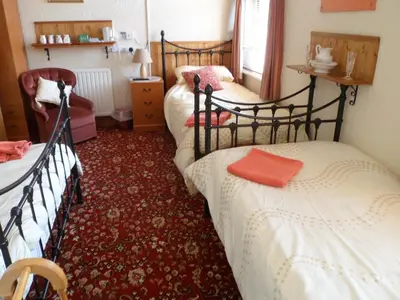 a bedroom with two beds and a red carpet at Camelot Hotel - Couples Only in Blackpool