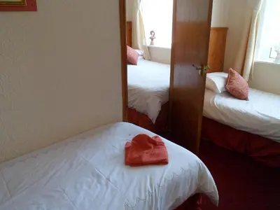a hotel room with two beds and a mirror at Camelot Hotel - Couples Only in Blackpool