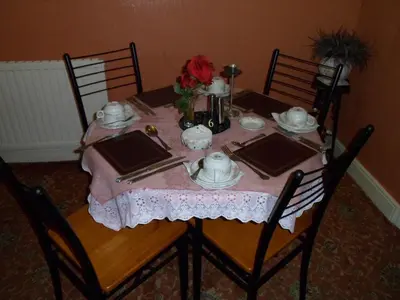 a table with a pink table cloth and a tea set at Camelot Hotel - Couples Only in Blackpool