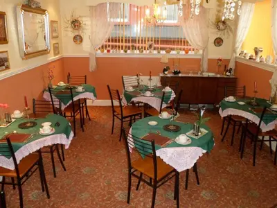 a dining room with green tables and chairs at Camelot Hotel - Couples Only in Blackpool