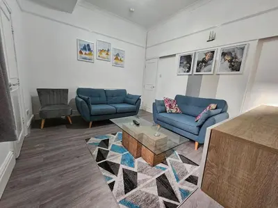 a living room with two blue couches and a coffee table at Cheerful Home near Preston train station & Uclan in Preston