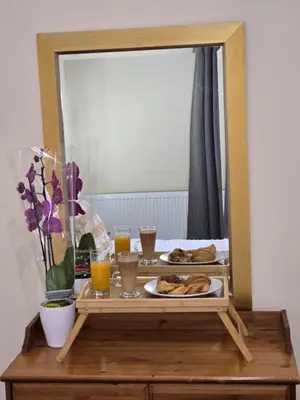 a table with a mirror and a plate of food at Cheerful Home near Preston train station & Uclan in Preston