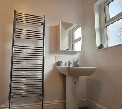 a bathroom with a sink and a mirror and a shower at Cheerful Home near Preston train station & Uclan in Preston