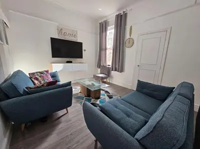 a living room with two blue couches and a tv at Cheerful Home near Preston train station & Uclan in Preston