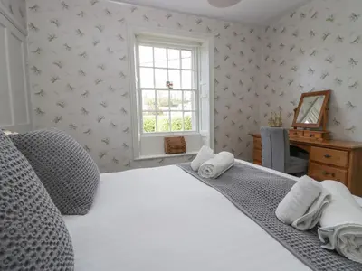 a bedroom with a white bed with towels on it at Holmere Bank in Carnforth
