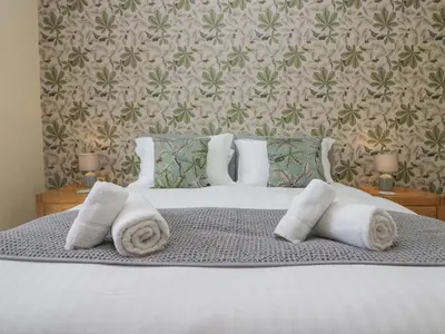 a bedroom with a bed with towels on it at Holmere Bank in Carnforth