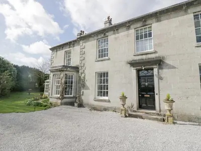 a stone house with a driveway in front of it at Holmere Bank in Carnforth