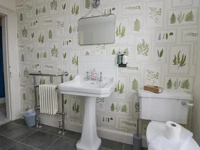 a bathroom with a sink and a mirror and a toilet at Holmere Bank in Carnforth