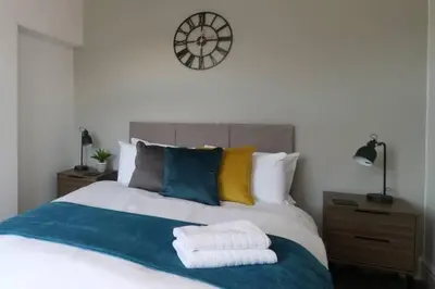 a bedroom with a bed with a clock on the wall at Lancaster 2 Bedroom Characterful House - with Wifi in Lancaster