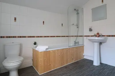 a bathroom with a toilet and a tub and a sink at Lancaster 2 Bedroom Characterful House - with Wifi in Lancaster