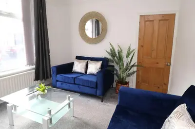 a living room with a blue couch and a table at Lancaster 2 Bedroom Characterful House - with Wifi in Lancaster