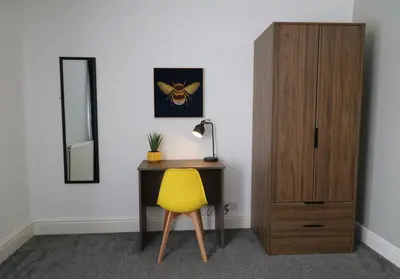 a desk with a yellow chair next to a mirror at Lancaster 2 Bedroom Characterful House - with Wifi in Lancaster