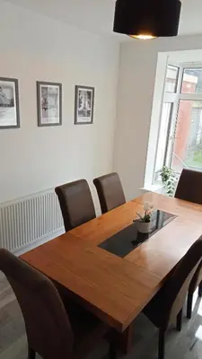 a wooden dining room table with chairs around it at Ribbleton Rendezvous in Preston in Preston