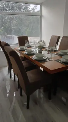a dining room table with chairs and a large window at Ribbleton Rendezvous in Preston in Preston