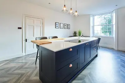 a kitchen with a blue island with a sink at Host & Stay - South View in High Newton