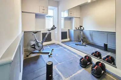 a room with a gym with a treadmill and a bike at Host & Stay - South View in High Newton