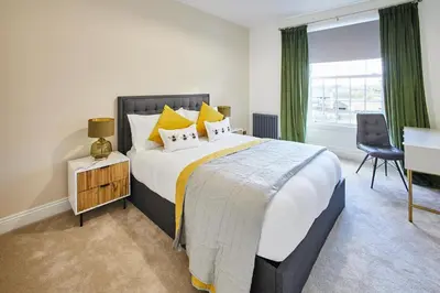 a bedroom with a large bed with yellow pillows at Host & Stay - South View in High Newton
