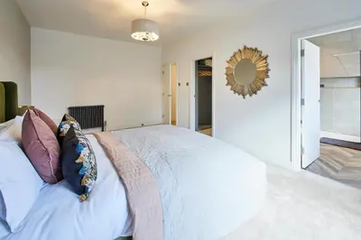 a bedroom with a bed and a mirror on the wall at Host & Stay - South View in High Newton