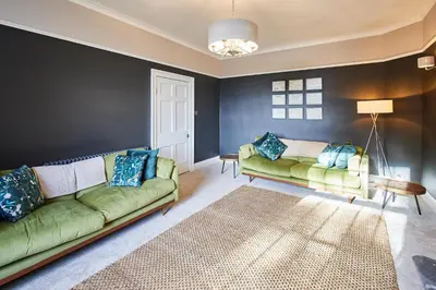 a living room with two green couches and a rug at Host & Stay - South View in High Newton
