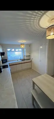 a room with a kitchen with a table and a counter at Entire 3 bedrooom holiday home in Liverpool
