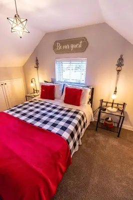 a bedroom with a large bed with a red and black checkered blanket at Loft apartment in Accrington Stunning Lancashire views in Church