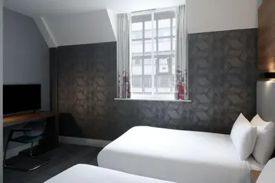 a hotel room with two beds and a window at Aloft Liverpool in Liverpool
