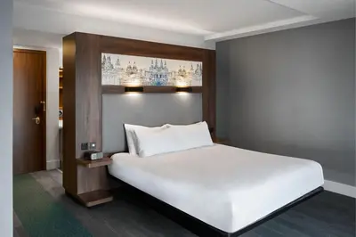 a bedroom with a large white bed and a window at Aloft Liverpool in Liverpool