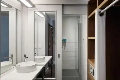 a bathroom with two sinks and two mirrors at Aloft Liverpool in Liverpool