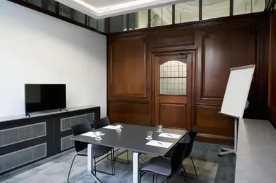 a meeting room with a table and chairs and a tv at Aloft Liverpool in Liverpool