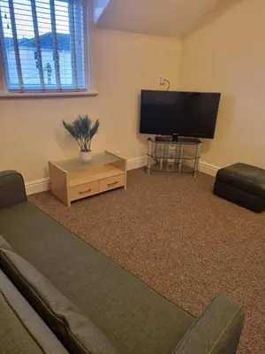 a living room with a couch and a flat screen tv at Lexham Apartments in Blackpool