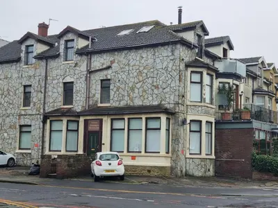 a white car parked in front of a stone house at Lexham Apartments in Blackpool